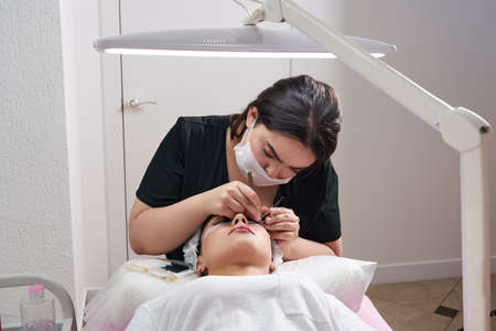 Eyelash Extension Procedure. Woman Eye with Long Eyelashes