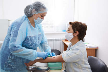 Nurse taking blood sample to make a test in laboratoryの写真素材