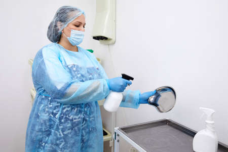 Nurse disinfecting medical instruments with sprayer in clinic. Disinfection conceptの写真素材