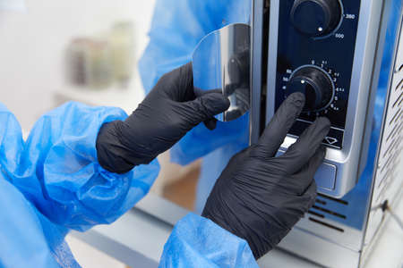 Laboratory worker operating Modern laboratory autoclave sterilizerの写真素材
