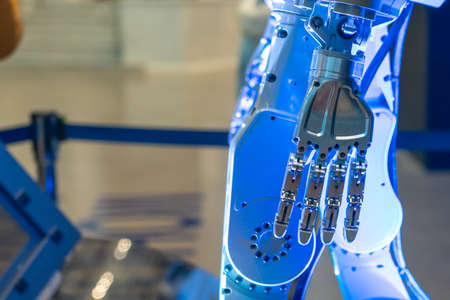 Closeup of metal robot hand. Concept of modern technology. Blue tone