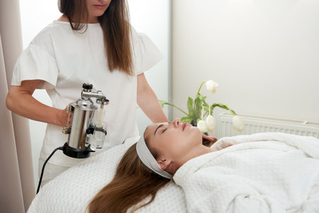 The procedure of steaming the skin of the face of a young woman before cleaning the skin in a cosmetology salonの写真素材