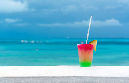 Cocktail with caribbean sea on background. Concept of beautiful tropical vacationの写真素材