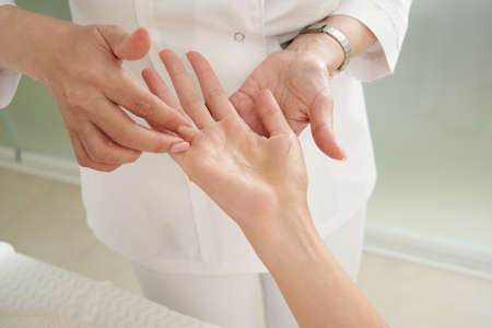 Young woman having an acupuncture treatment therapy on hand in spa salon. Alternative medicine...