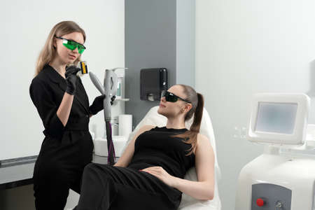 Young woman receiving laser treatment in cosmetology clinicの写真素材