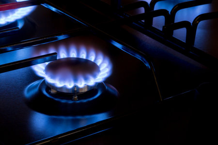 Gas burner with blue burnig methane flame on dark backgroundの写真素材