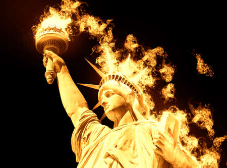 Statue of Liberty with burning fire isolated on black backgroundの写真素材