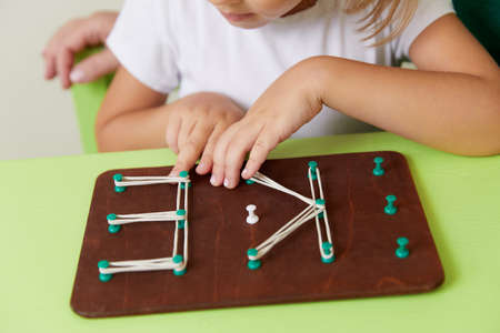 Woman teaches child the alphabet. Development of fine motor skills conceptの写真素材
