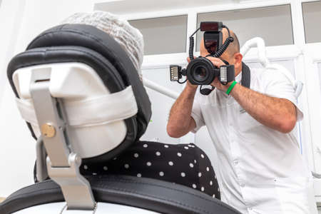 Dentist photographing patients teeth for medical record before and after surgery in dentist officeの写真素材