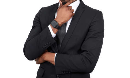 serious African american businessman touching chin wearing black suit isolated on white backgroundの写真素材