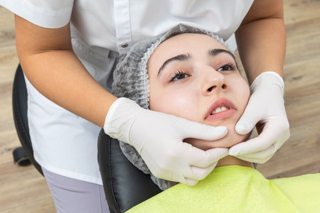 Dentist looks at a jaw of female patient checking the bite