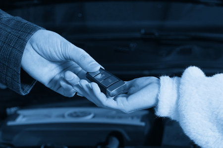Mechanic giving car keys to customer after servicingの写真素材