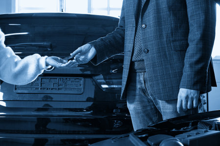 Mechanic giving car keys to customer after servicingの写真素材