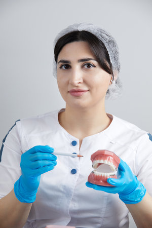 Orthodontist showing model of human jaw with wire braces and aligners explaining the difference