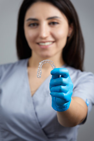 Dentist holdind orthodontic transparent silicone trainer or aligner for teeth correctionの写真素材