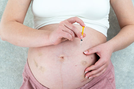Pregnant woman making injection in stomachの写真素材