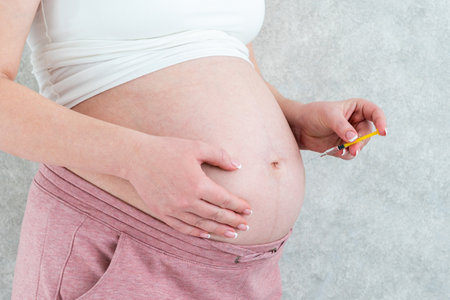 Blood thinners concept. Pregnant woman making injection in stomachの写真素材