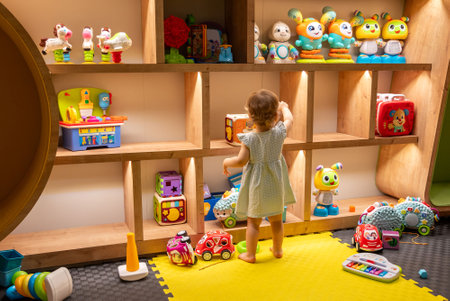 Toddler girl playing at kindergarten with toys. Concept of daycare for babiesの写真素材