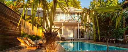 Luxurious villa with swimming pool and lush tropical garden. Concept of serene outdoor relaxation and high-end livingの写真素材