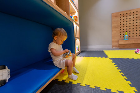 Child playing with a toy in colorful playroom. Concept of early childhood learning and creativityの写真素材