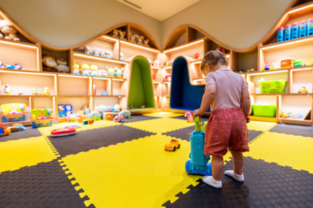 Child exploring a bright and organized indoor playroom with toys and activity stationsの写真素材