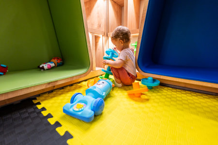 Toddler playing with educational toys in a colorful playroom designed for fun and creativityの写真素材