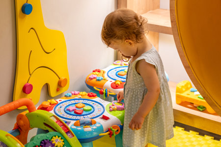 Child focused on an educational toy in a bright room. Concept of early learning and discoveryの写真素材