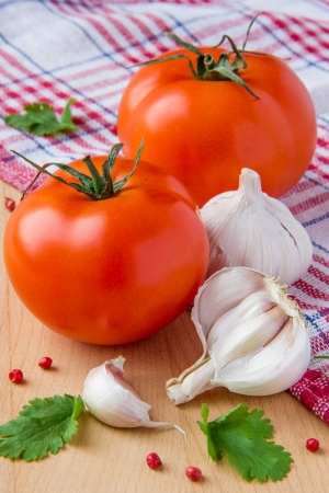 Tomatoes, cilantro and garlic on chequered red towel の写真素材