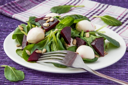 Fresh salad with roasted beets, spinach, mozzarella and seeds の写真素材