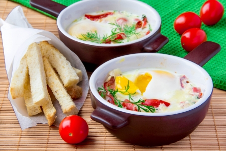 Baked eggs with cheese, tomatoes and croutonsの写真素材
