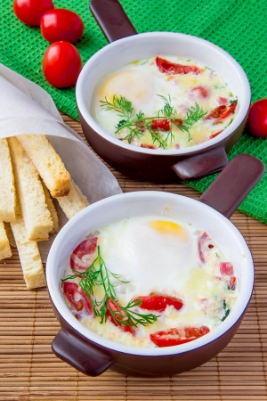 Baked eggs with cheese, tomatoes and croutonsの写真素材