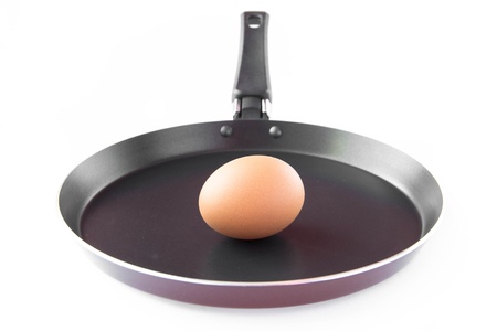 Isolated black frying pan with raw eggの写真素材