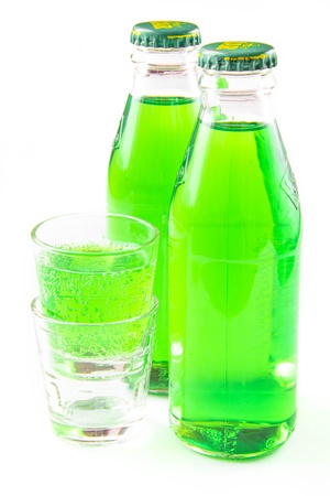 Green lemonade in  two bottle and small glass on whiteの写真素材