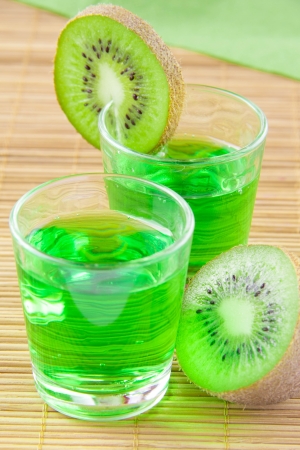Green kiwi drink in small glass on bambooの写真素材