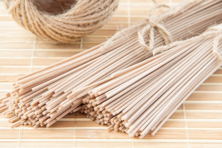 Uncooked buckwheat noodles on bamboo for pastaの写真素材