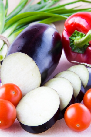 Sliced aubergine, a bunch of green spring onions, cherry tomatoes and pepperの写真素材