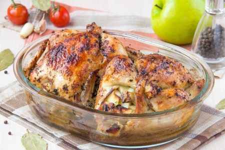 Two small baked chicken, stuffed with apples with ruddy crust in form for bakingの写真素材