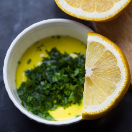 Fresh salad dressing of olive oil, lemon juice and herb parsley in white cupの写真素材