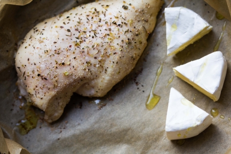 Baked fillet chicken breast with spices, brie, Camembert cheese, cooking in an ovenの写真素材