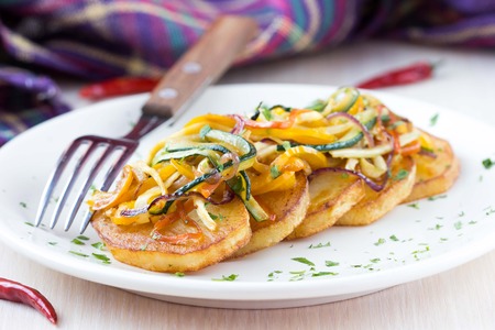 Fried slices of potato with finely chopped sticks vegetables, lean, vegetarian dish for dinnerの写真素材