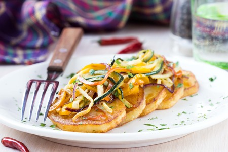 Fried slices of potato with finely chopped sticks vegetables, lean, vegetarian dish for dinnerの写真素材
