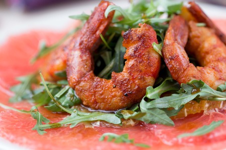Carpaccio of grapefruit with rucola, arugula salad and spicy fried prawns, shrimpの写真素材