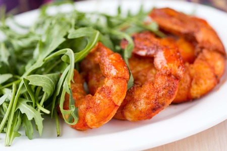 Fried spicy shrimp, prawn and salad of arugula, rukkolaの写真素材