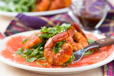 Carpaccio of grapefruit with rucola, arugula salad and spicy fried prawns, shrimpの写真素材