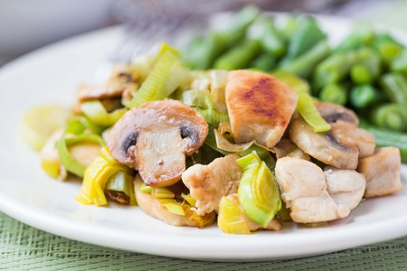 Chicken fillet fried with onions leek, mushrooms champignon, green leguminous beans, cream sauceの写真素材