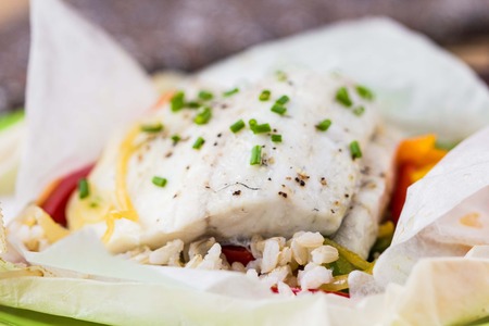 White fish fillet baked in paper, parchment with rice, vegetables, pepper, tatsy diet dish