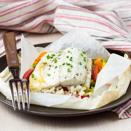 White fish fillet baked in paper, parchment with rice, vegetables, pepper, tatsy diet dishの写真素材
