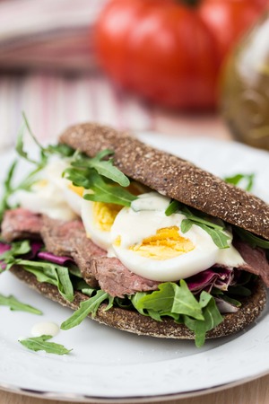 Sandwich with grilled beef steak, eggs, arugula, rye bread, tatsy lunchの写真素材