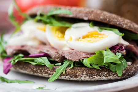 Sandwich with grilled beef steak, eggs, arugula, rye bread, tatsy lunchの写真素材
