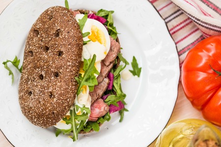 Sandwich with grilled beef steak, eggs, arugula, rye bread, tatsy lunchの写真素材
